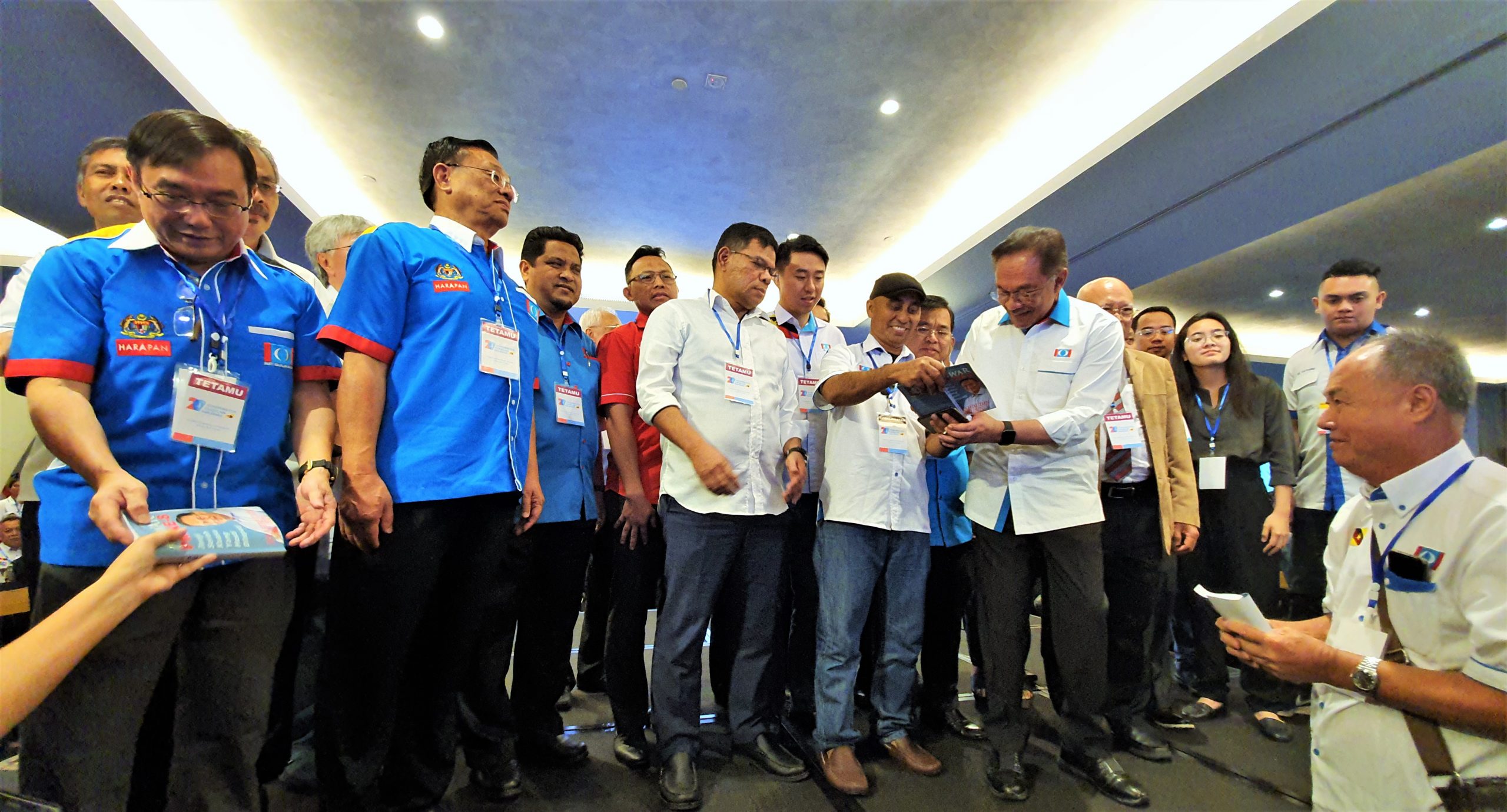 Anwar (fifth left, front) doing a book signing.